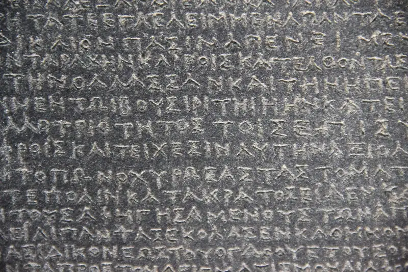 Close-up of the Greek inscription carved into the dark granodiorite of the Rosetta Stone